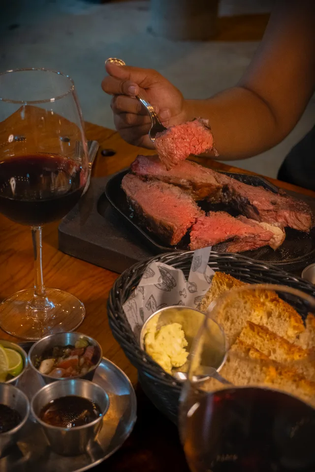Carne a la parrilla, pan y vino para compartir